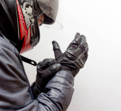 Motorcycle,guy,wearing,helmet,and,leather,jacket,gearing,up